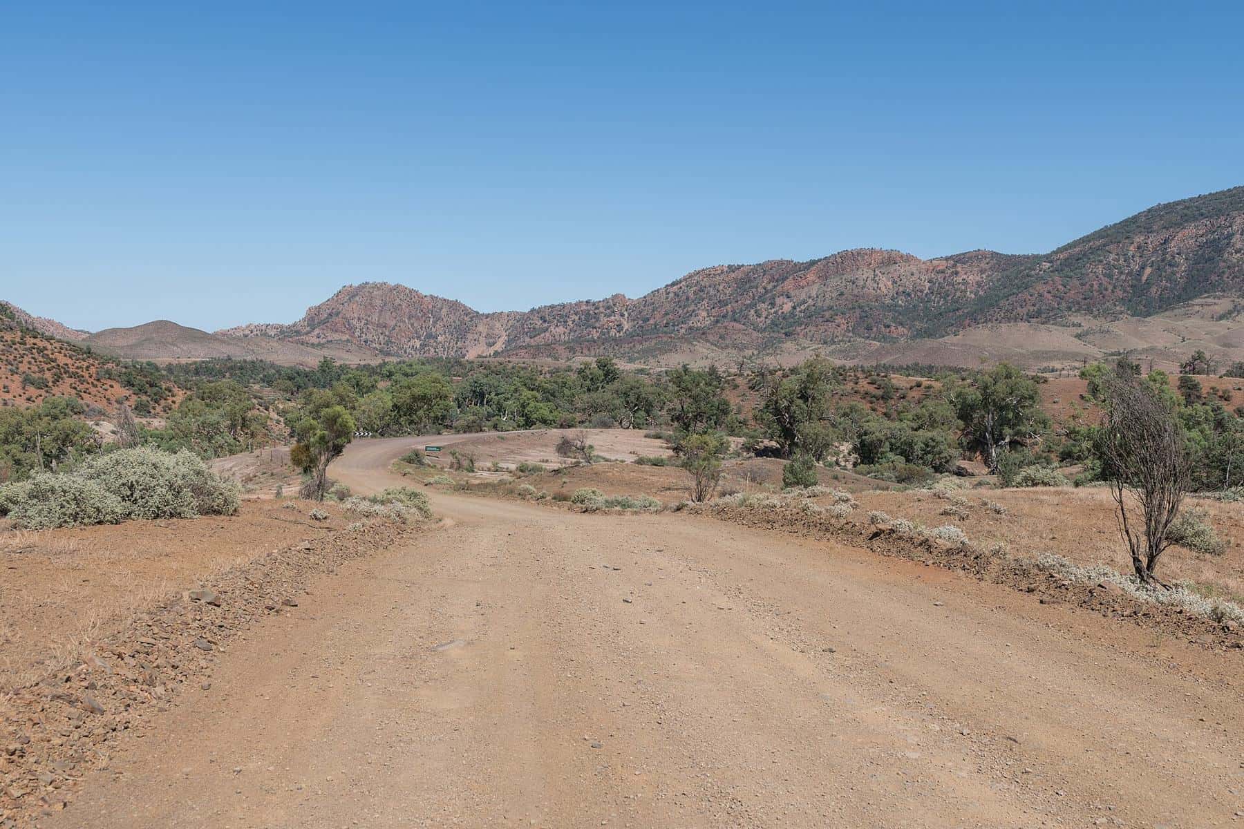 Unsealed road through Brachina Gorge with red rock walls