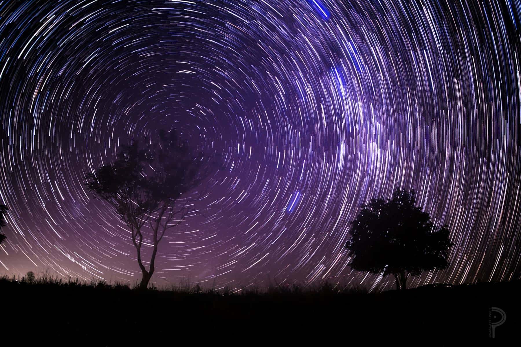 The Milky Way above a dark landscape at night