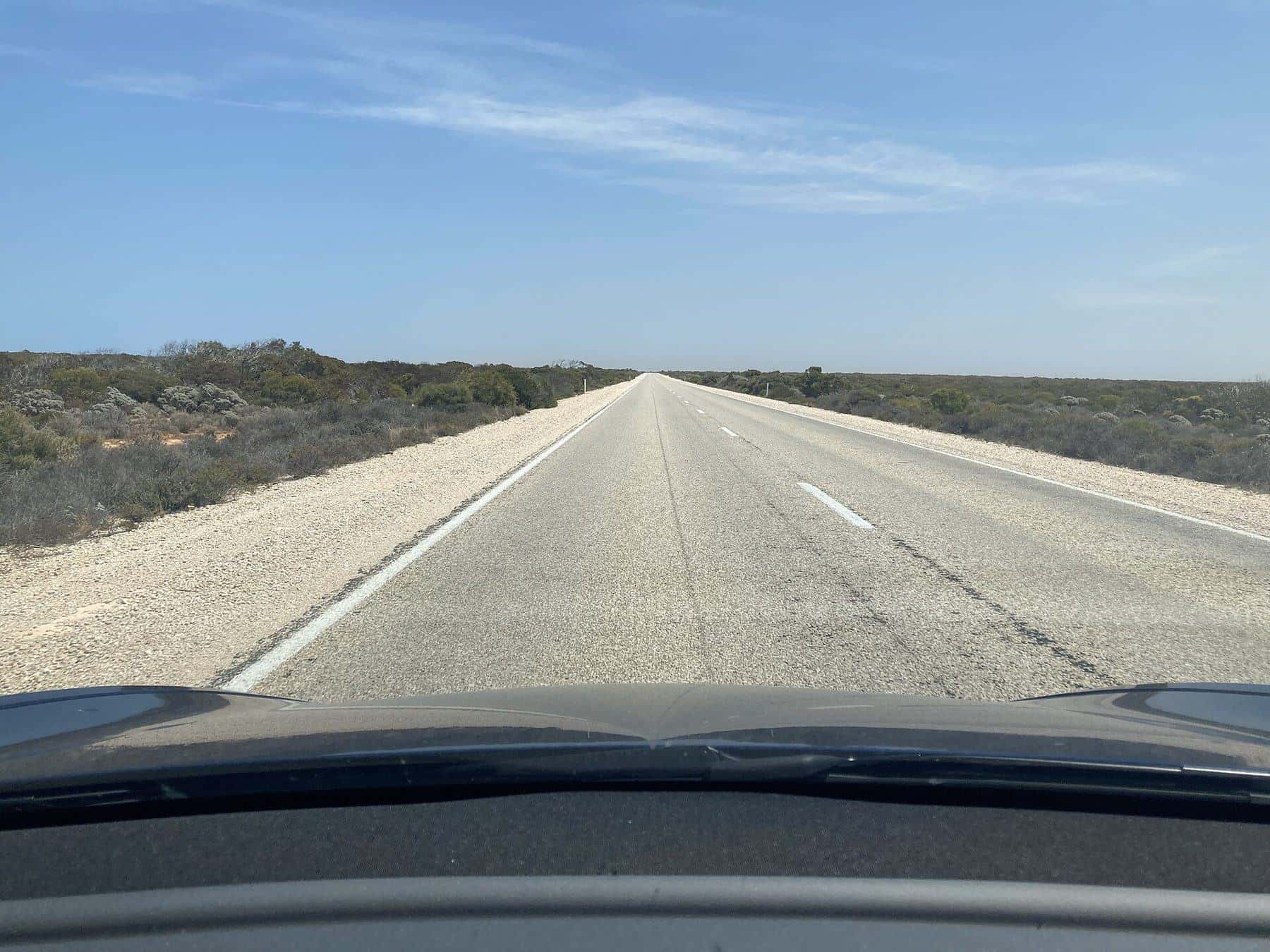 The Eyre Highway running straight to the horizon across the Nullarbor Plain